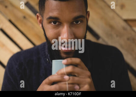 Close up portrait of young man having coffee while sitting in cafe Banque D'Images