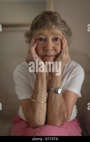 Portrait of senior woman sitting on sofa in living room Banque D'Images