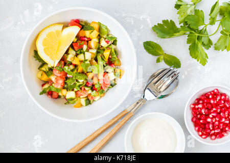 Taboulé salade rustique, l'arrière-plan en béton blanc, bol, plat arabe. Banque D'Images