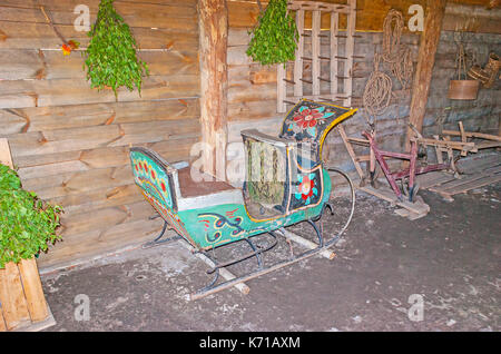 Suzdal, Russie - 1 juillet 2013 : le porche intérieur de l'ancien journal izba - le traîneau peint est au mur et les manches de bouleau pour le bain russe accrocher sur i Banque D'Images