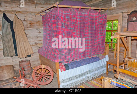 Suzdal, Russie - 1 juillet 2013 : recréé de l'intérieur de la chambre de séjour dans la région de log maison paysanne avec un lit à baldaquin et d'un rouet, et tisser, musée de woo Banque D'Images