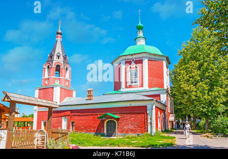 Suzdal, Russie - 1 juillet 2013 : La promenade le long de la rue ombragée avec vue sur la cité médiévale de bâtiment rouge église de l'assomption du Kremlin de Souzdal, neighb Banque D'Images