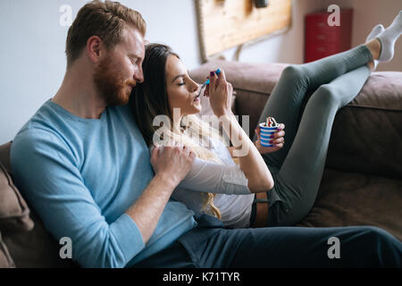 Romantic couple eating ice cream ensemble et regarder la télévision Banque D'Images