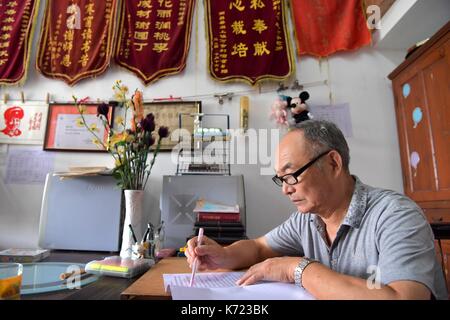 (170914) -- nanchang, sept. 14, 2017 (Xinhua) -- il xingwu travaille dans son bureau à une école spéciale à Nanchang, province de Jiangxi en Chine de l'Est, sept. 13, 2017. Les 74 ans, enseignant, il xingwu a travaillé dans l'école spéciale depuis 23 ans. Il a perdu l'audition à l'âge de huit ans en raison de l'utilisation inappropriée de médicaments. En 1994, lui et son ami a fondé l'école après sa retraite. plus de 300 à l'audition et des malentendants francophones les étudiants ont obtenu un diplôme de l'école. (Xinhua/peng zhaozhi) (zkr)(zt) Banque D'Images