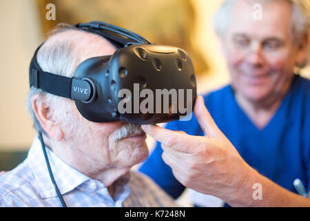 Dpatop - friedhelm caspers, chef gériatrie médecin, mettre une paire de lunettes de réalité virtuelle sur un patient atteint de démence dans creveld, Allemagne, 14 septembre 2017. assistance numérique devrait ralentir les processus de démence et d'Alzheimers. Les patients peuvent se déplacer à travers des scènes de rue à partir des années 1950, et ainsi faire un voyage dans leur propre passé. photo : marius becker/dpa Banque D'Images