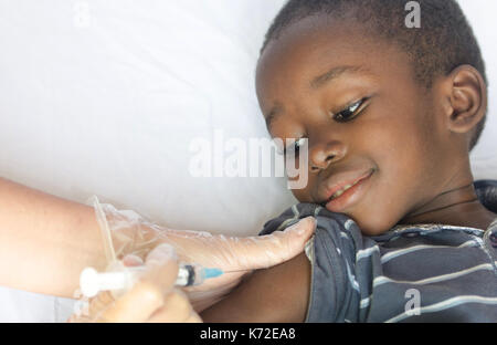 Black African boy reçoit une injection médicale comme un projet de soins de santé pour l'Afrique Banque D'Images