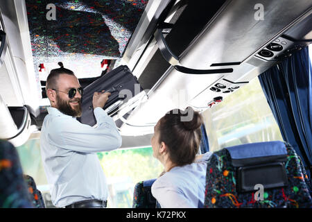 Bagages à main. Le bus touristique conducteur a introduit une petite valise dans le coffre à l'intérieur du véhicule. Banque D'Images