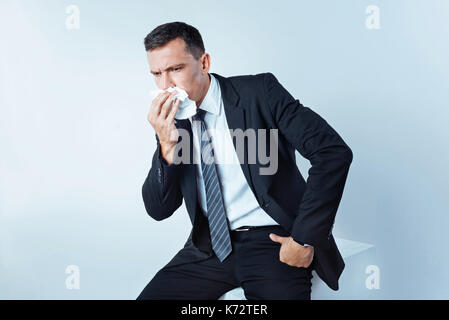 Entrepreneur sérieux en fonction de l'éternuement fort au contexte Banque D'Images