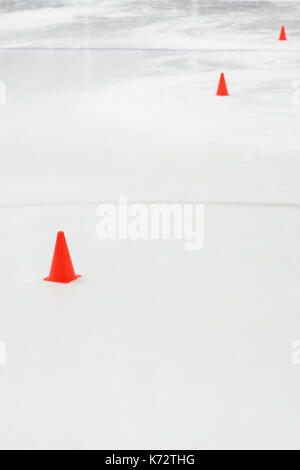 Cônes d'entraînement sportif au hockey sur glace rink vide Banque D'Images