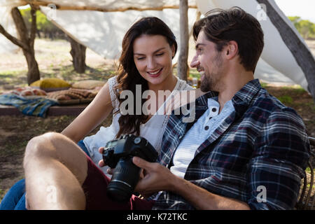 Smiling young man par femme avec caméra sur terrain Banque D'Images