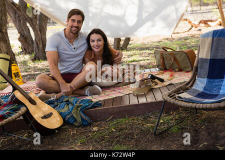 Portrait of young couple relaxing in tent Banque D'Images