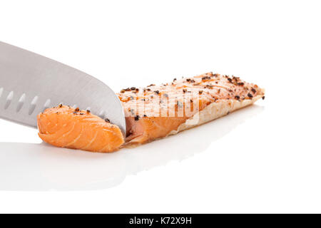 Chef cuisinier avec couteau et slicing raw salmon pour faire des filets de poissons. Banque D'Images