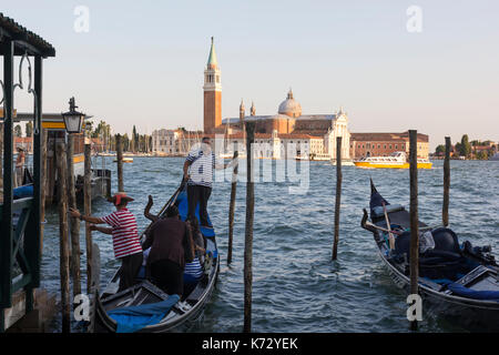 Gondoliers avec leurs gondoles en face de la place San Marco à Venise, Italie. l'île San Giorgio Maggiore est dans l'arrière-plan. Banque D'Images