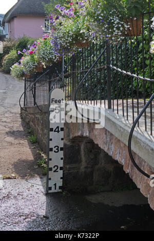 Jauge de profondeur indiquant le niveau d'eau d'un ruisseau à l'entrée d'un village du Devon Banque D'Images