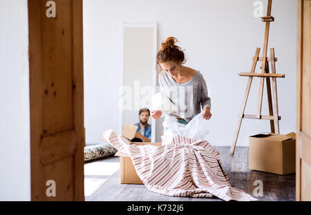 Deux jeunes mariés déménagement en nouvelle maison, déballage des boîtes. Banque D'Images