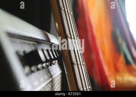 Les musiciens d'une guitare basse et un ampli basse avec un tie dye tapisserie en arrière-plan. Banque D'Images