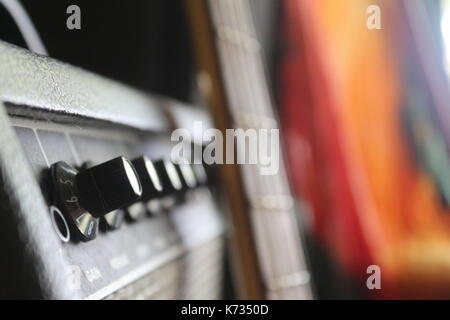 Les musiciens d'une guitare basse et un ampli basse avec un tie dye tapisserie en arrière-plan. Banque D'Images