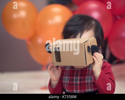 Baby Girl playing vr goggle casque en carton Banque D'Images