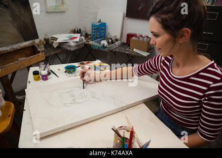 Femme attentionné esquisse sur toile en classe de dessin Banque D'Images