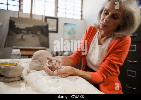 Senior woman attentif de la pâte à modeler en classe de dessin Banque D'Images