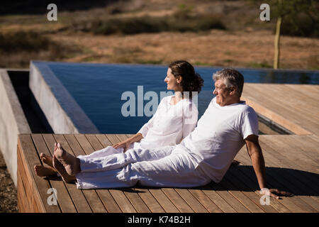 Couple relaxing on planche en bois sur une journée ensoleillée Banque D'Images