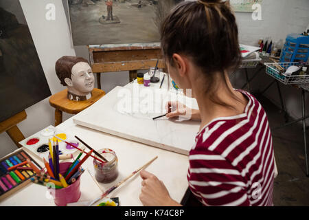 Femme attentionné esquisse sur toile en classe de dessin Banque D'Images