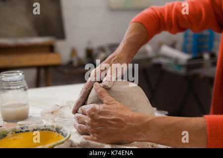 La mi-section of senior woman molding clay en classe de dessin Banque D'Images