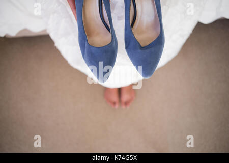 High angle portrait of elderly chaussures bleu alors qu'il était assis dans la salle de montage Banque D'Images