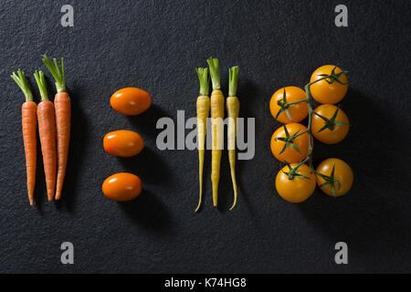 Frais généraux de carottes et tomates sur fond noir Banque D'Images