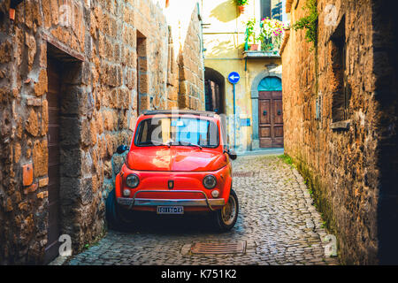 Ancienne fiat 500 rouge garée dans une ruelle étroite, classic car, Orvieto, Ombrie, Italie Banque D'Images