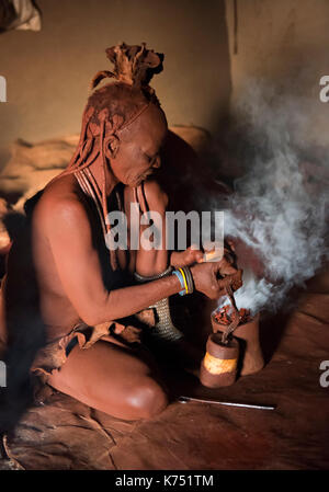 Femme himba, désinfection des vêtements, la Namibie, le kaokoveld Banque D'Images