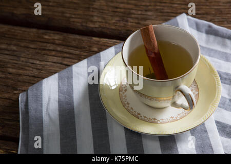 Close-up of tea cup avec le bâton de cannelle sur nappes Banque D'Images