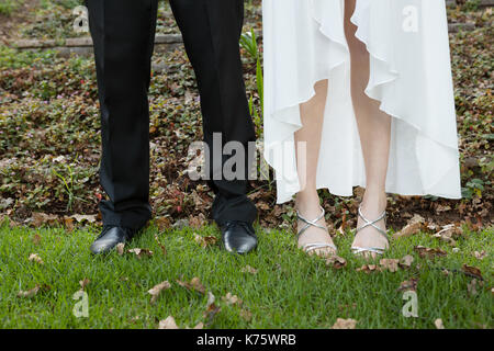 La section basse de young woman standing on grassy field Banque D'Images