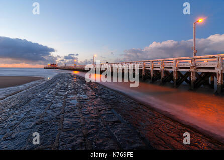 Une longue exposition photo de la jetée à Ostende au coucher du soleil avec vue sur la mer du Nord, la Belgique. Banque D'Images