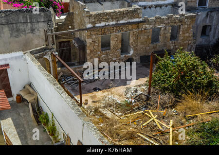 Une mère allaite son chat deux chatons dans les anciennes ruines d'une ville de Rhodes en Grèce. Banque D'Images