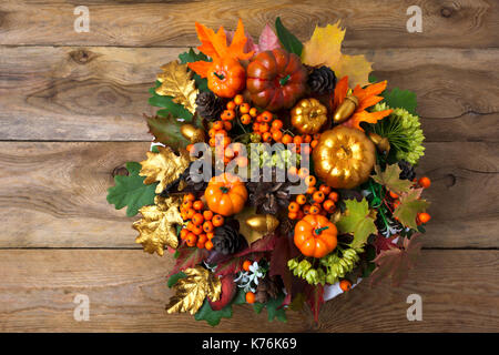 Couronne de grâce avec les citrouilles et les feuilles d'automne sur la vieille table en bois. centre de table d'automne avec des baies et des cônes, copy space Banque D'Images