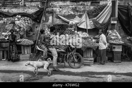 Vegetable stall impromptus le long de la rue en ruine avec les fournisseurs et le public et de chien dans cette rue à Varanasi, Inde. Banque D'Images