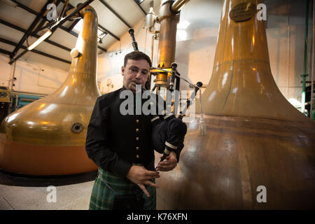 La distillerie de whisky Bowmore avec cornemuse, à Bowmore, en Ecosse, le 15 septembre 2017. Banque D'Images