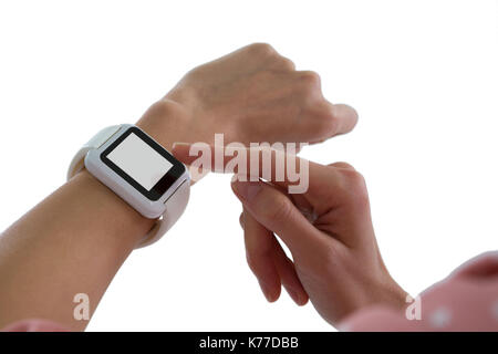 La main à l'aide de womans smartwatch against white background Banque D'Images