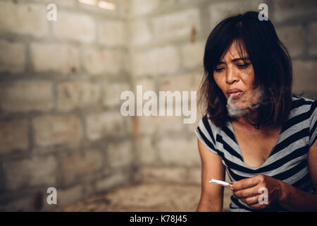 Jeune femme toxicomane avec seringue dans l'action, concept de l'abus des drogues. Banque D'Images