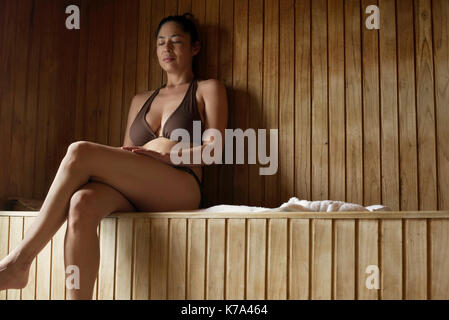 Woman sitting in sauna Banque D'Images