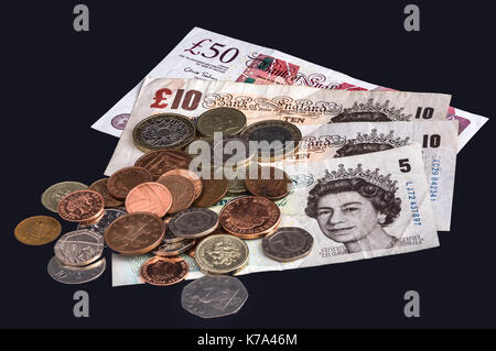 Billets et pièces britanniques sur un fond noir. Banque D'Images