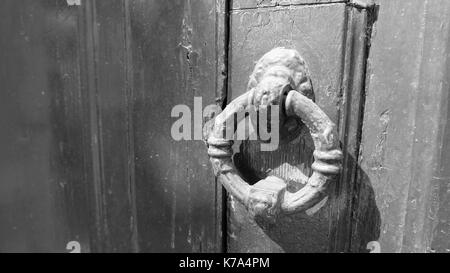 Le noir et blanc ou monochrome photo d'une rustique vintage metal Poignee de porte sur une porte en bois. Banque D'Images