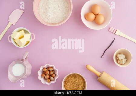 Flatlay collection d'outils et ingrédients pour pâtisseries maison avec copyspace au centre sur fond rose en plongée des Banque D'Images