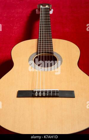 Guitare acoustique sur tissu velours rouge, objet gros plan Banque D'Images
