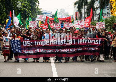 Manille, Philippines. 15 Sep, 2017. Les protestataires sont vues tenant une bannière de l'écriture sur elle 'US : # 1 impérialiste terroriste" tout en criant des slogans au cours d'une manifestation tient par les peuples autochtones de l'île de Mindanao. Composé principalement d'autochtones de Mindanao, (la deuxième plus grande île des Philippines) des centaines de manifestants ont marché vers l'ambassade des États-Unis pour protester contre les idées politiques du président américain Donald Trump et les Philippines président Rodrigo Duterte à Roxas Boulevard avant d'être bloqués par le contrôle de la foule des agents de police de Kalaw Avenue, à quelques centaines de mètres de la Banque D'Images