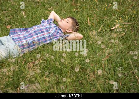 Boy sieste sur l'herbe Banque D'Images