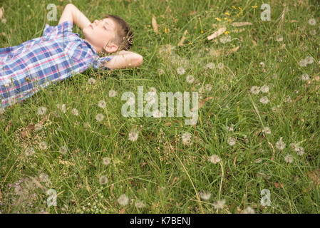 Boy sieste sur l'herbe Banque D'Images
