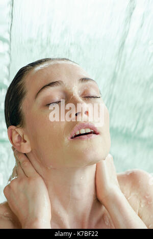 Woman bathing in cascade artificielle Banque D'Images