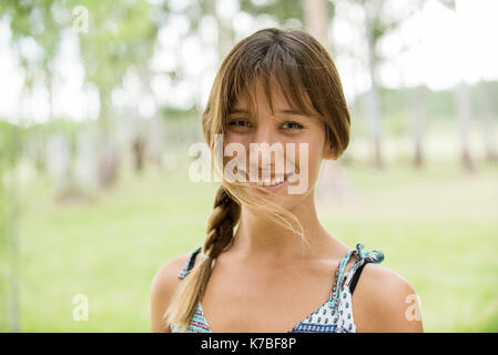 Young woman smiling gaiement outdoors, portrait Banque D'Images